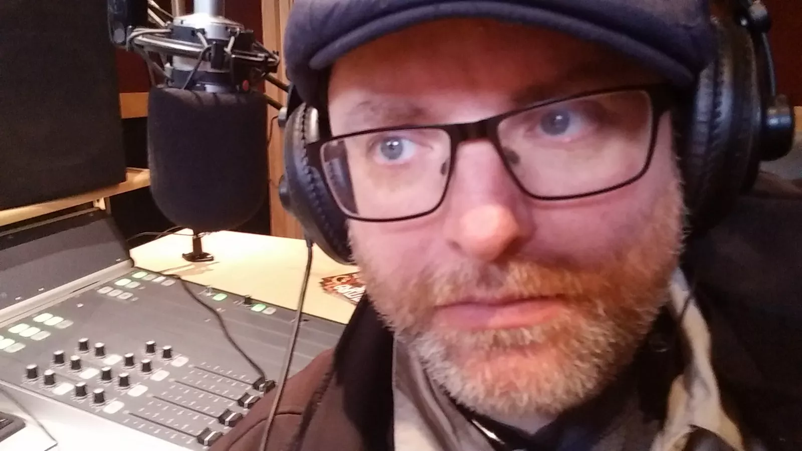 Dominik wearing headphones beside a studio microphone